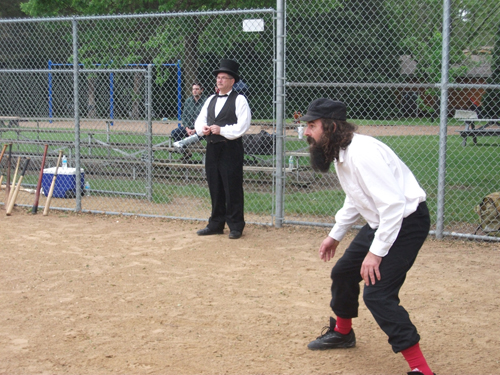 Afton behind Ray "Stash" Hanson waits for the pitch while Umpire Simonet watches the action